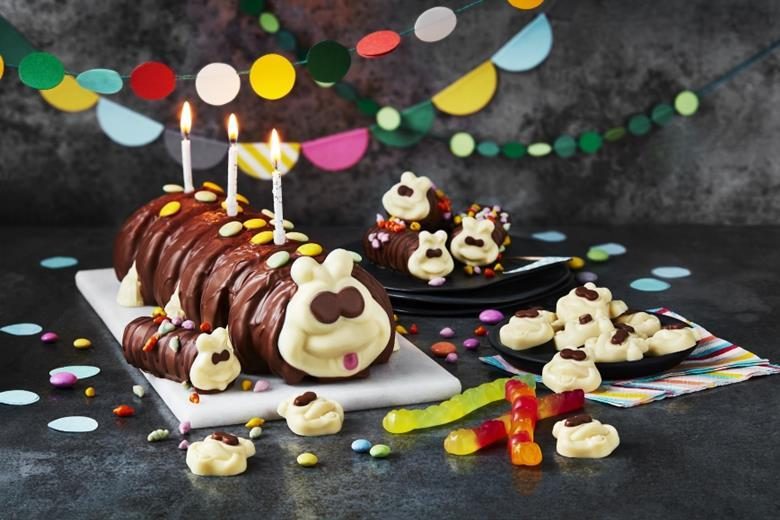 A finished chocolate caterpillar celebration cake with candles